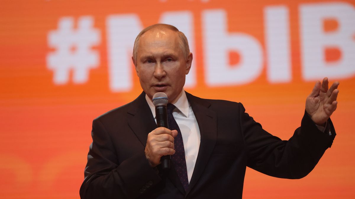 Na zdjęciu Władimir Putin z mikrofonem w dłoni