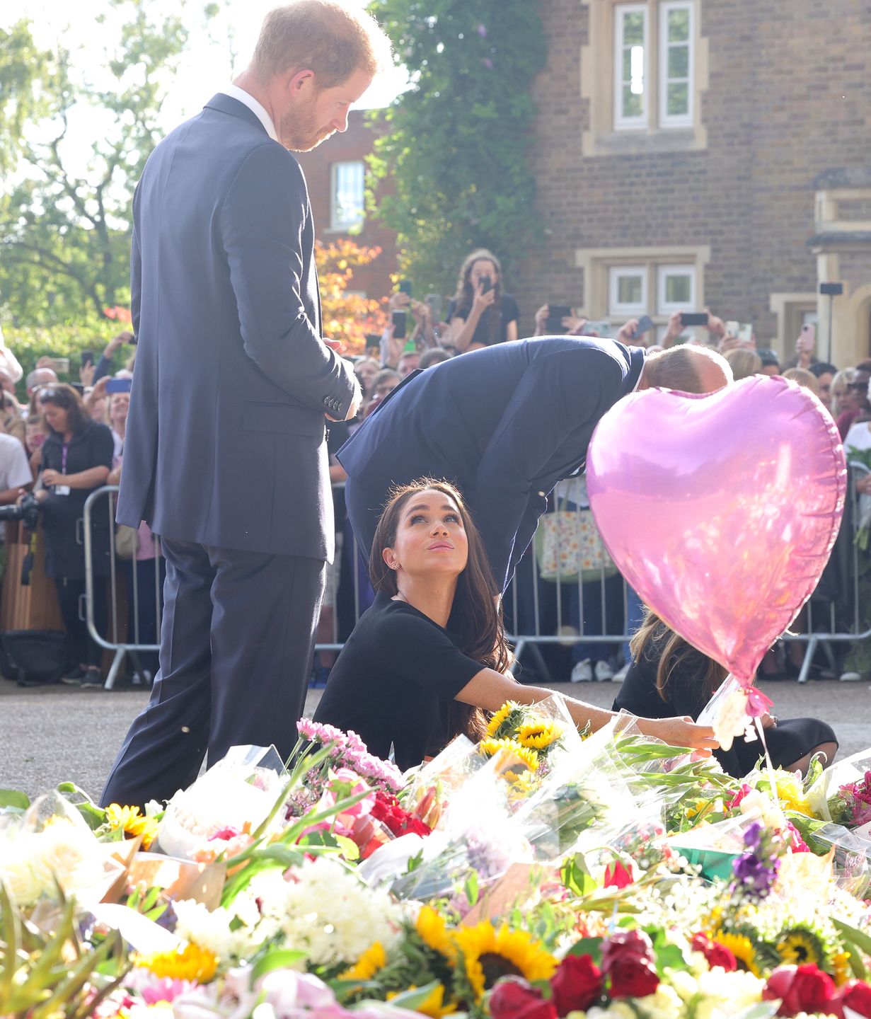 WINDSOR, ENGLAND - SEPTEMBER 10: Catherine, Princess of Wales, Prince William, Prince of Wales, Prince Harry, Duke of Sussex, and Meghan, Duchess of Sussex on the long Walk at Windsor Castle arrive to view flowers and tributes to HM Queen Elizabeth on September 10, 2022 in Windsor, England. Crowds have gathered and tributes left at the gates of Windsor Castle to Queen Elizabeth II, who died at Balmoral Castle on 8 September, 2022. (Photo by Chris Jackson/Getty Images)