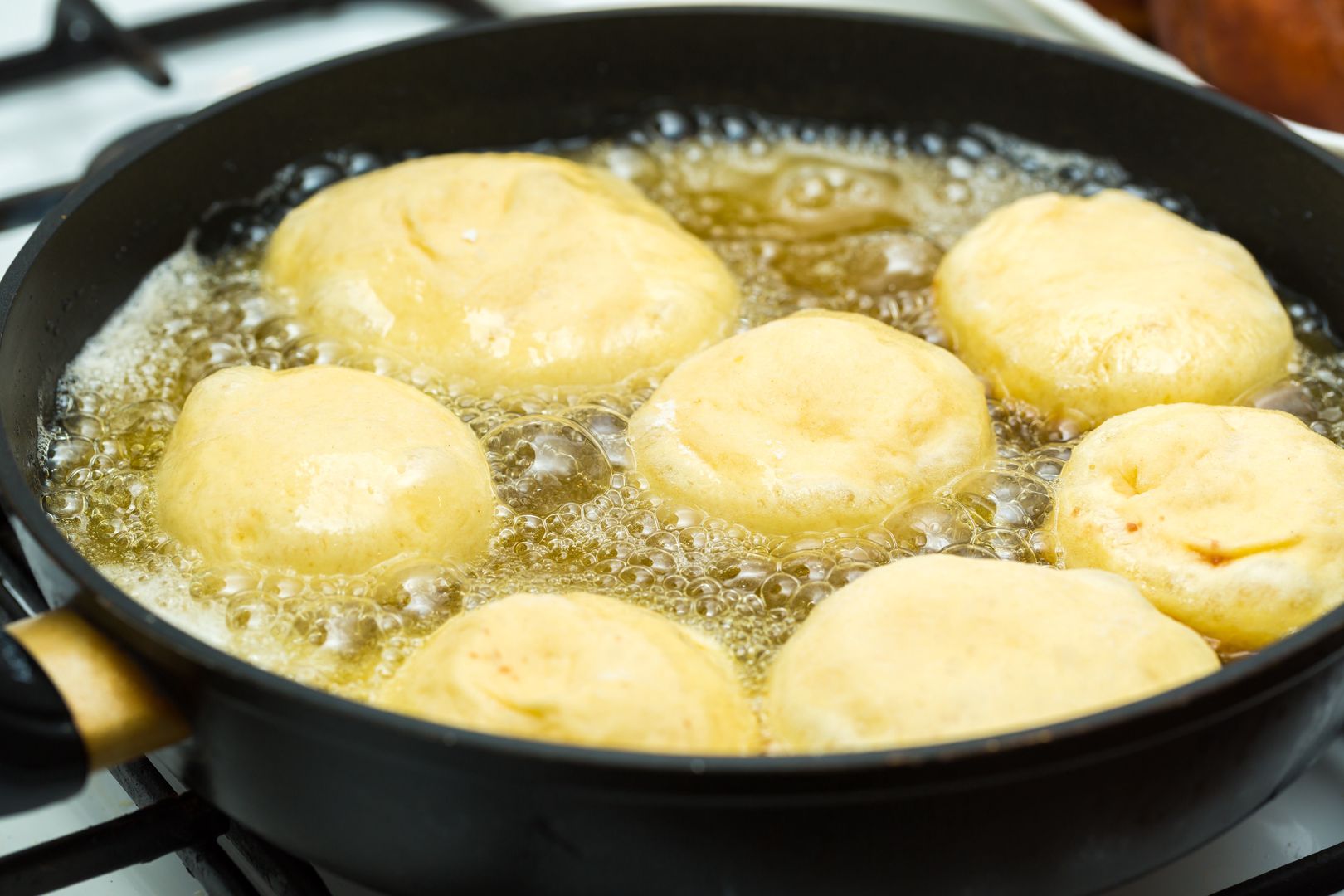 Donuts frying in deep fat. Preparation of traditional donutssugar, food, pastry, sweet, cooking, bakery, fry, oil, meal, snack, traditional, tasty, restaurant, dessert, doughnut, delicious, nutrition, unhealthy, preparation, kitchen, donut, cook, manufacture, many, manufacturing, fried, fresh-baked, tradition, typical, production, cooked, cuisine, dish, making, polish, round, stuffed, homemade, cream, eating, diet, dairy, gourmet, bake, cookie