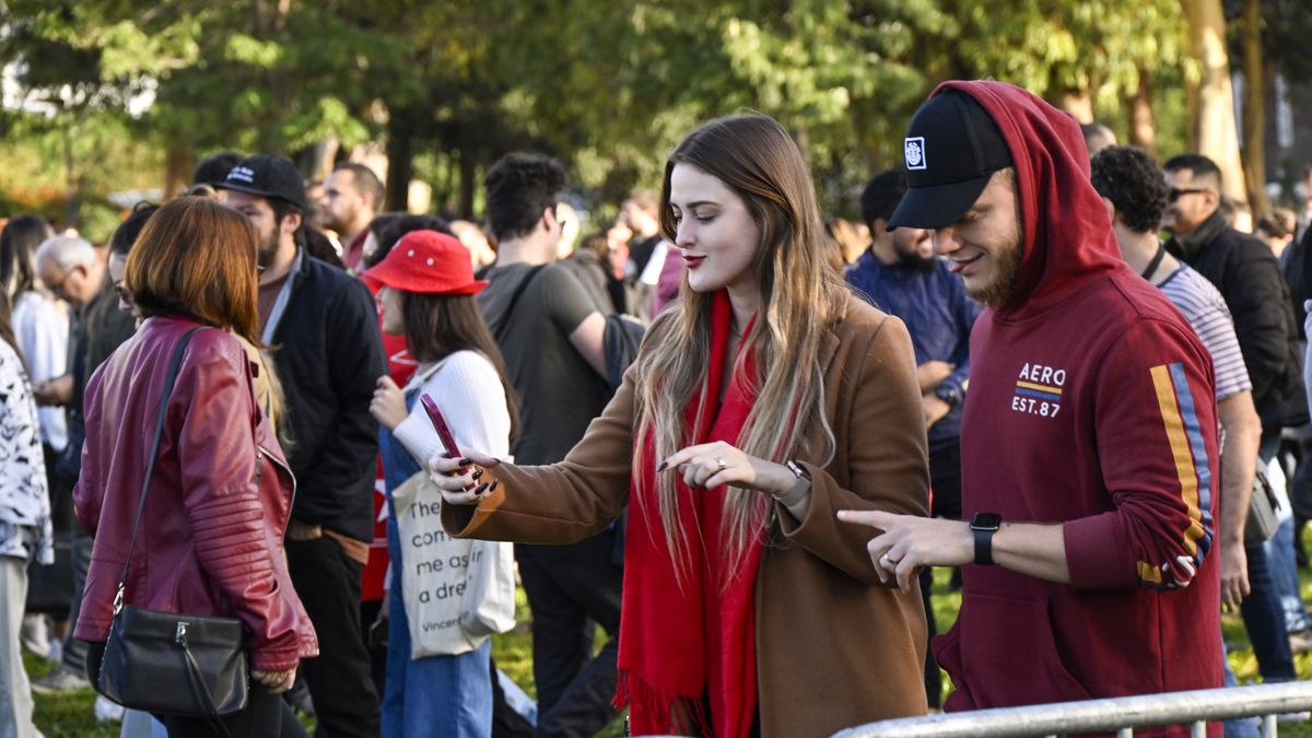 LISBON, PORTUGAL - OCTOBER 30: A couple takes selfies while  walking in line outside Lisbon University Law School to cast their ballot in the second round of Brazilian presidential election at Law School in Lisbon University on October 30, 2022 in Lisbon, Portugal. Brazilians registered to vote in Portugal are able to do so in the cities of Lisbon, Porto and Faro, Some 45,000 registered Brazilian voters in Lisbon make the largest voting registered community in Europe. 80,000 registered voters in Portugal make this country the 2nd largest registered community, only surpassed by USA, outside Brazil. Two candidates running for the Brazilian presidency qualified for 2nd round: incumbent President Jair Bolsonaro and ex-President Luiz Inácio Lula da Silva, who came in first on 1st round, but without the necessary votes to avoid a second voting round. (Photo by Horacio Villalobos#Corbis/Corbis via Getty Images)