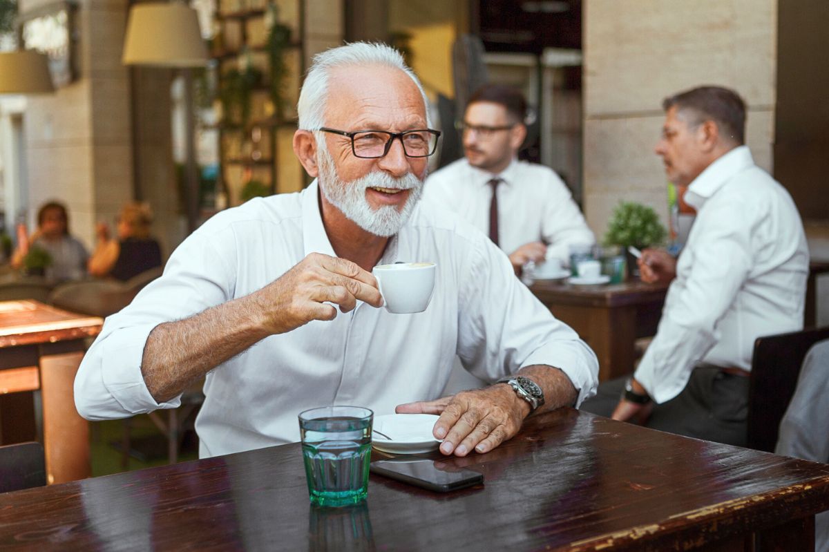 The senior is drinking coffee.