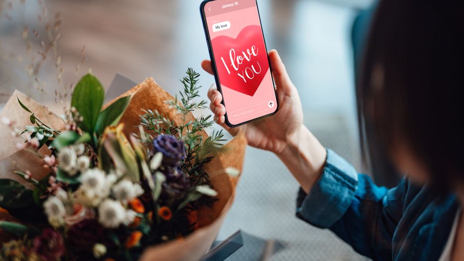 Kobieta trzymająca kwiaty i telefon 