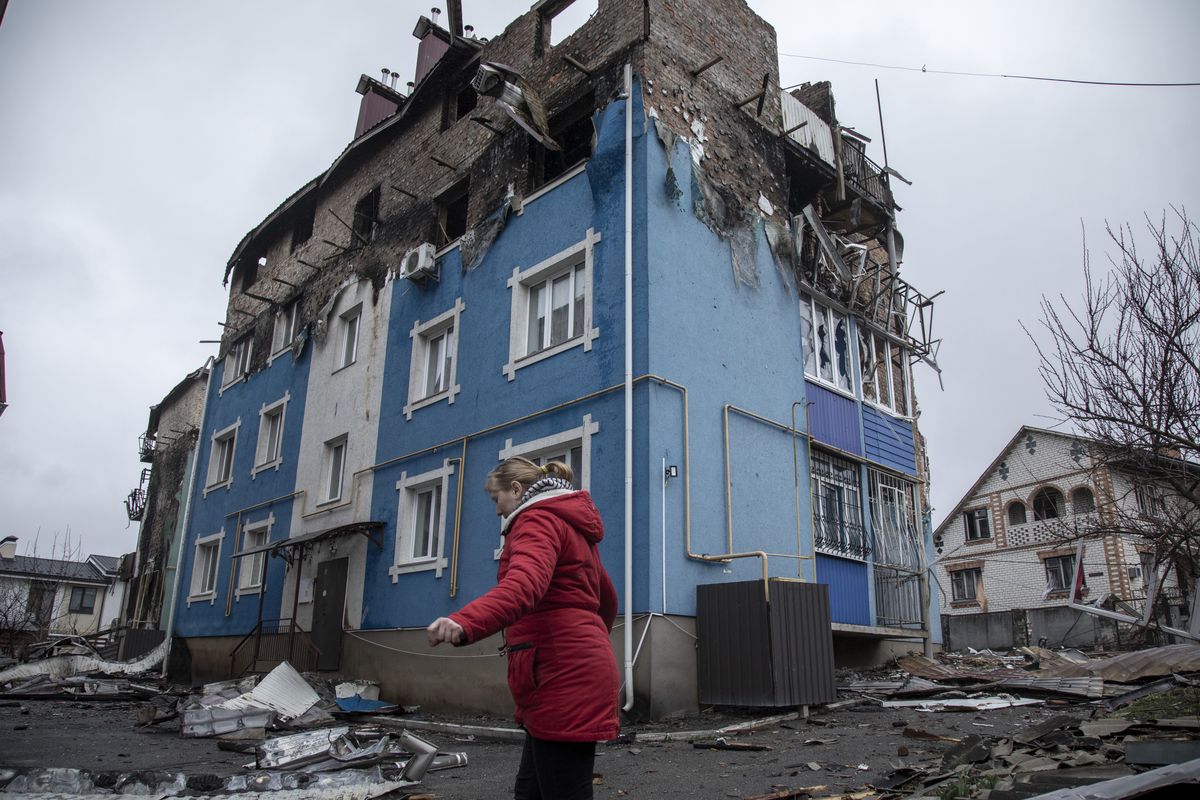 IRPIN, KYIV PROVINCE, UKRAINE, APRIL 02: A local resident woman walks near by damaged buildings in the surroundings of her neighborhood in Irpin district, after Ukrainian servicemen secured the area following the withdrawal of the Russian army from the Kyiv region on previous days, Irpin, Ukraine, April 2nd, 2022. (Photo by Narciso Contreras/Anadolu Agency via Getty Images)