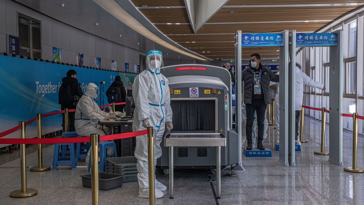 epa09716296 Staff wearing protective gear check passengers at a railway station after their arrival on a special Olympic train to Zhangjiakou, inside the Olympic COVID-19 'bubble', China, 29 January 2022. Zhangjiakou is the co-host city of the Beijing 2022 Winter Olympics which is scheduled to start on 04 February 2022.  EPA/ROMAN PILIPEY Dostawca: PAP/EPA.