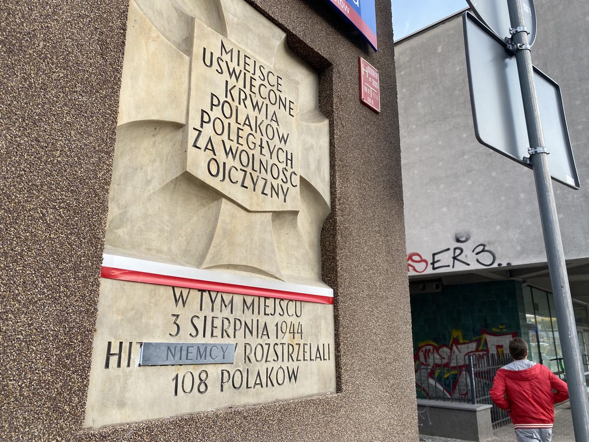 Warszawa. Wandal przykleja piankową naklejkę na tablice z piaskowca, upamiętniające miejsca martyrologii Polaków podczas II wojny  światowej. Do akcji przyznał się dam Borowski z Klubu "Gazety Polskiej" (Barbara Kwiatkowska)