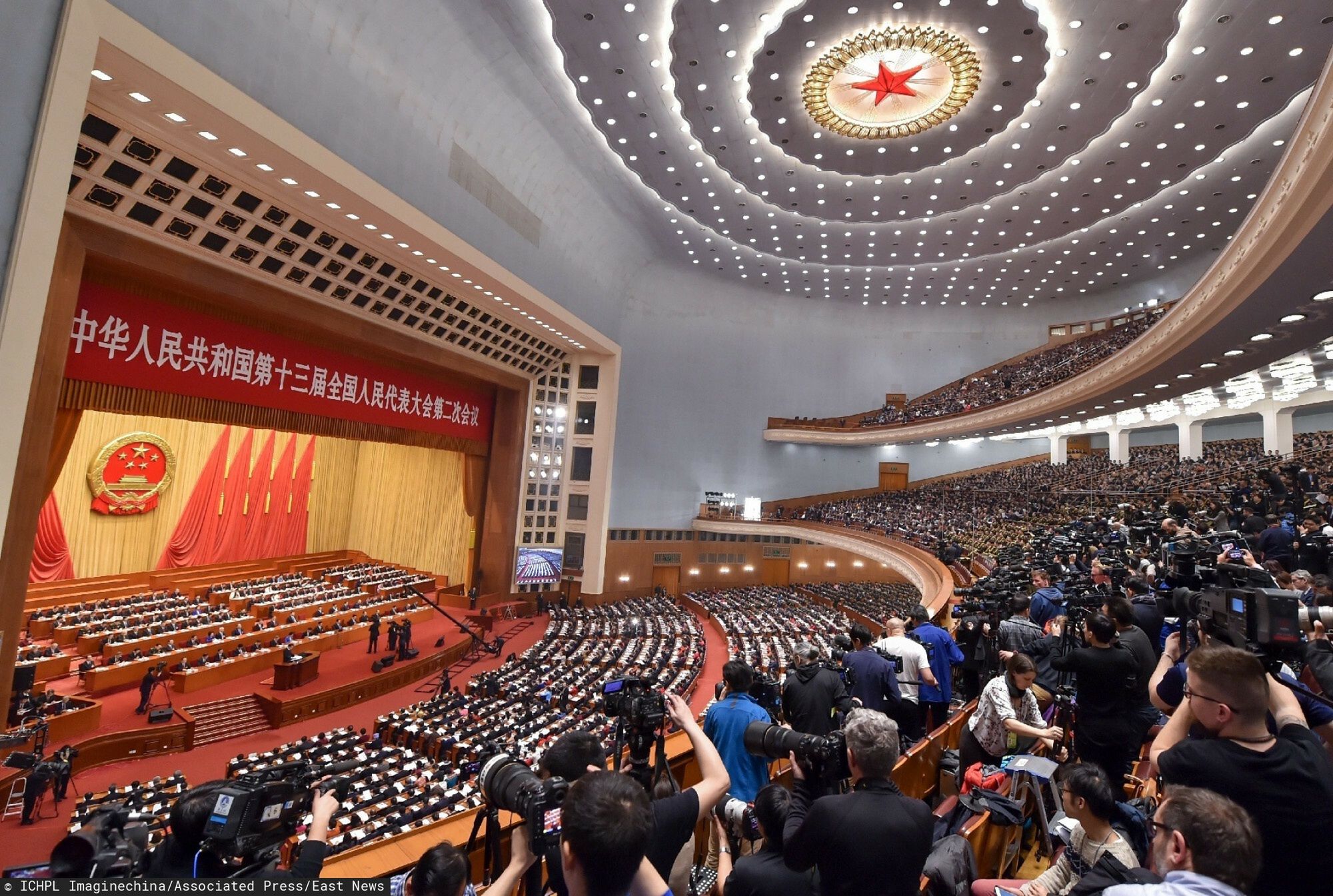 arch34Deputies attend the opening meeting for the second session of the 13th National People's Congress (NPC) at the Great Hall of the People in Beijing, China, 5 March 2019. The 13th National People's Congress (NPC), China's national legislature, opened its second session Tuesday morning at the Great Hall of the People in Beijing. Xi Jinping and other leaders of the Communist Party of China and the state were present at the opening meeting, which was attended by nearly 3,000 NPC deputies. Li Keqiang delivered the government's work report on behalf of the State Council to the legislature for deliberation. Li said though China faced a complicated and challenging environment rarely seen in many years with the economy under new downward pressure, the nation managed to accomplish main targets for economic and social development in 2018. Looking to 2019, Li said it is necessary to sustain healthy economic development and maintain social stability to create a pivotal underpinning for completing the building of a moderately prosperous society in all respects and to mark the 70th anniversary of the founding of the People's Republic of China with outstanding accomplishments.  (Imaginechina via AP Images)ICHPL Imaginechina