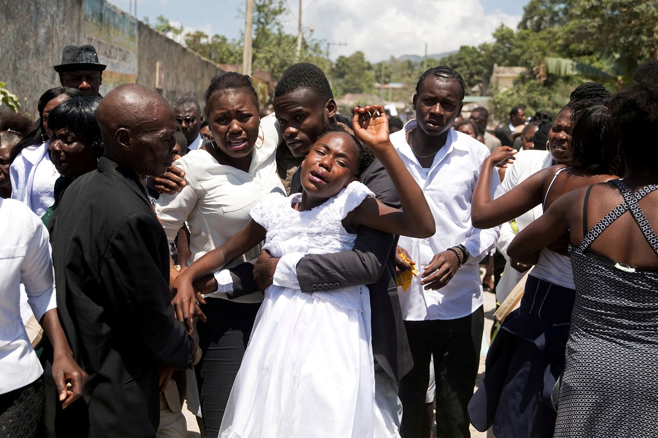 30.03.2021 r., Haiti. 13-letnia Naika Joseph oraz jej 18-letni brak Rodelin Joseph uczestniczą w uroczystości żałobnej wraz z kuzynami oraz bratankami zmarłej Violette Jean przy cmentarzy w Plaisance na Haiti.