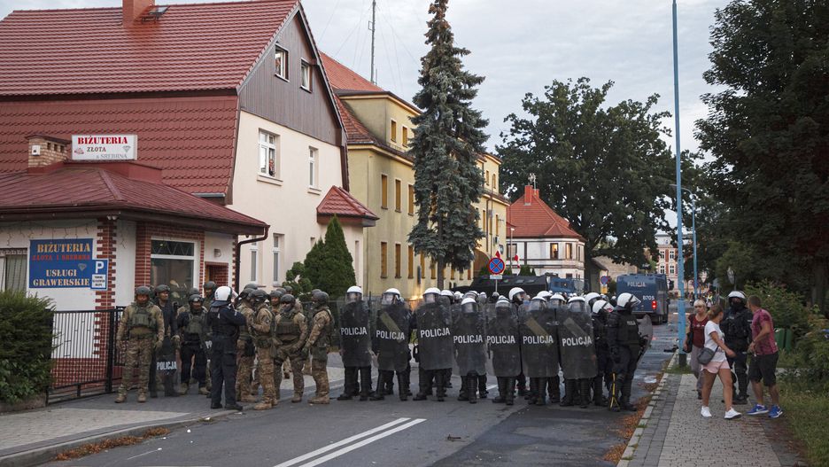 Lubin, 08.08.2021. Policja podczas protestu przed Komendą Powiatową Policji na ul. Traugutta w Lubinie, 8 bm. W piątek 6 bm. policjanci interweniowali w sprawie mężczyzny, który miał być pod wpływem narkotyków i rzucać w okna mieszkańców kamieniami. Policjanci po przybyciu go obezwładnili. Protestujący uważają że mężczyzna zmarł podczas interwencji. (aldg) PAP/Aleksander Koźmiński