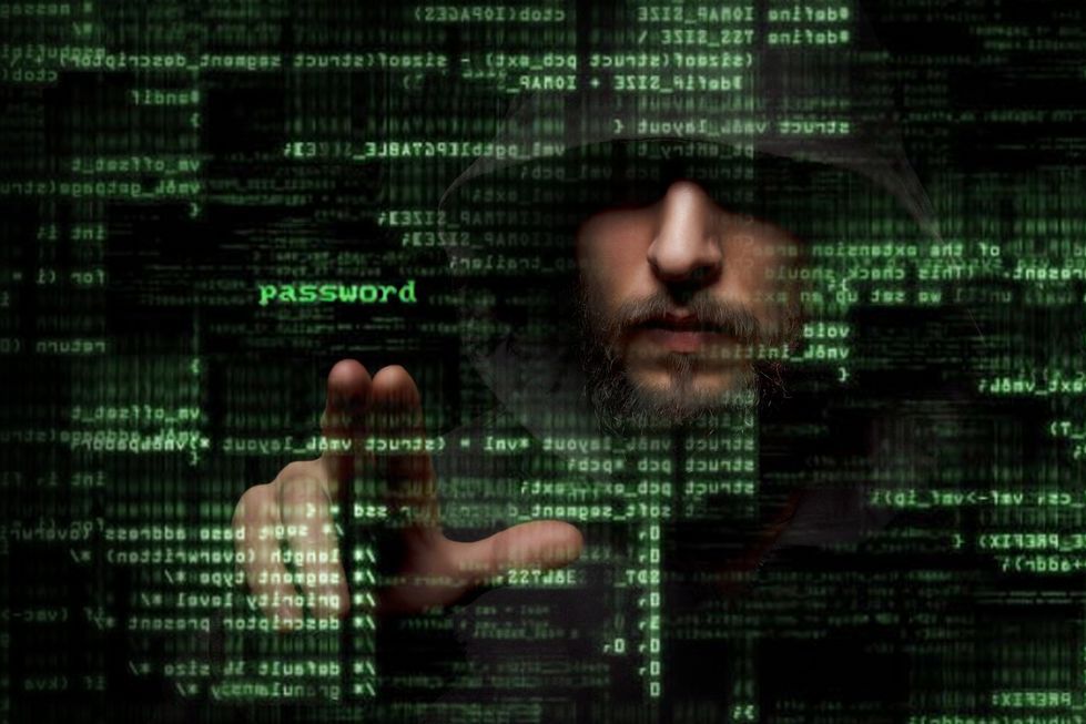 Zdjęcie Silhouette of a hacker looking in monitor with binary codes and words pochodzi z serwisu Shutterstock