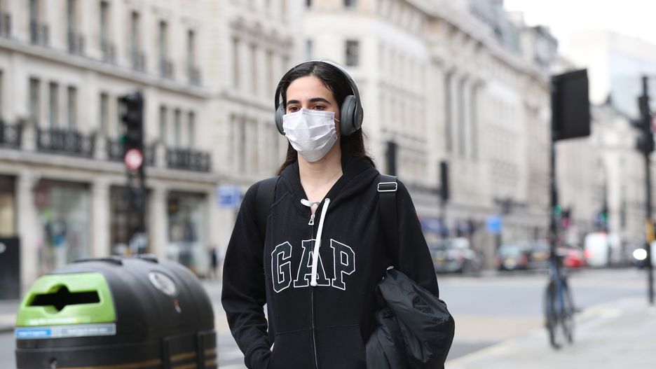 A woman wearing a face mask in Regents Street in London the day after Prime Minister Boris Johnson called on people to stay away from pubs, clubs and theatres, work from home if possible and avoid all non-essential contacts and travel in order to reduce the impact of the coronavirus pandemic. (Photo by Jonathan Brady/PA Images via Getty Images)