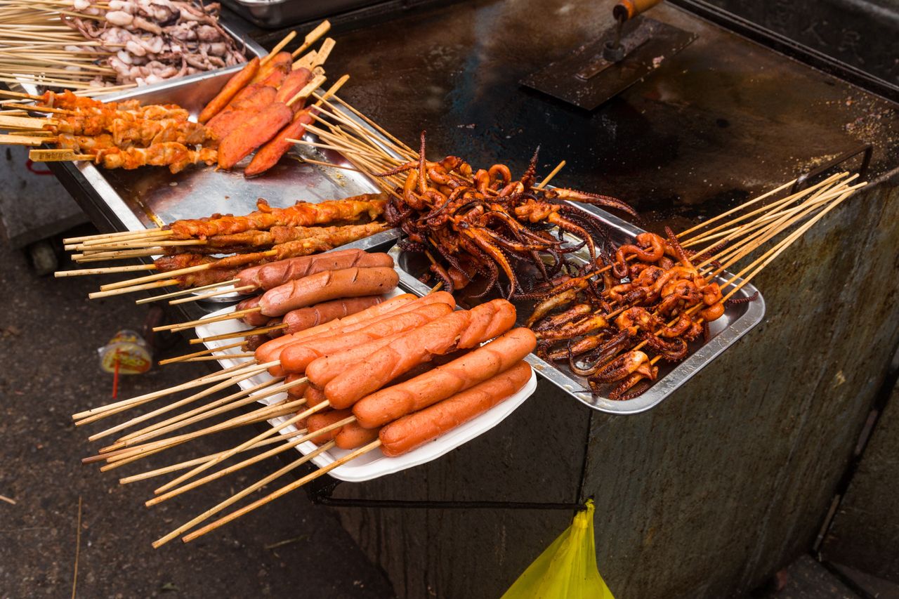 Skewers of grilled hot dogs, octopus tentacles and meat for sale on the street in Old Town, Shanghai, China