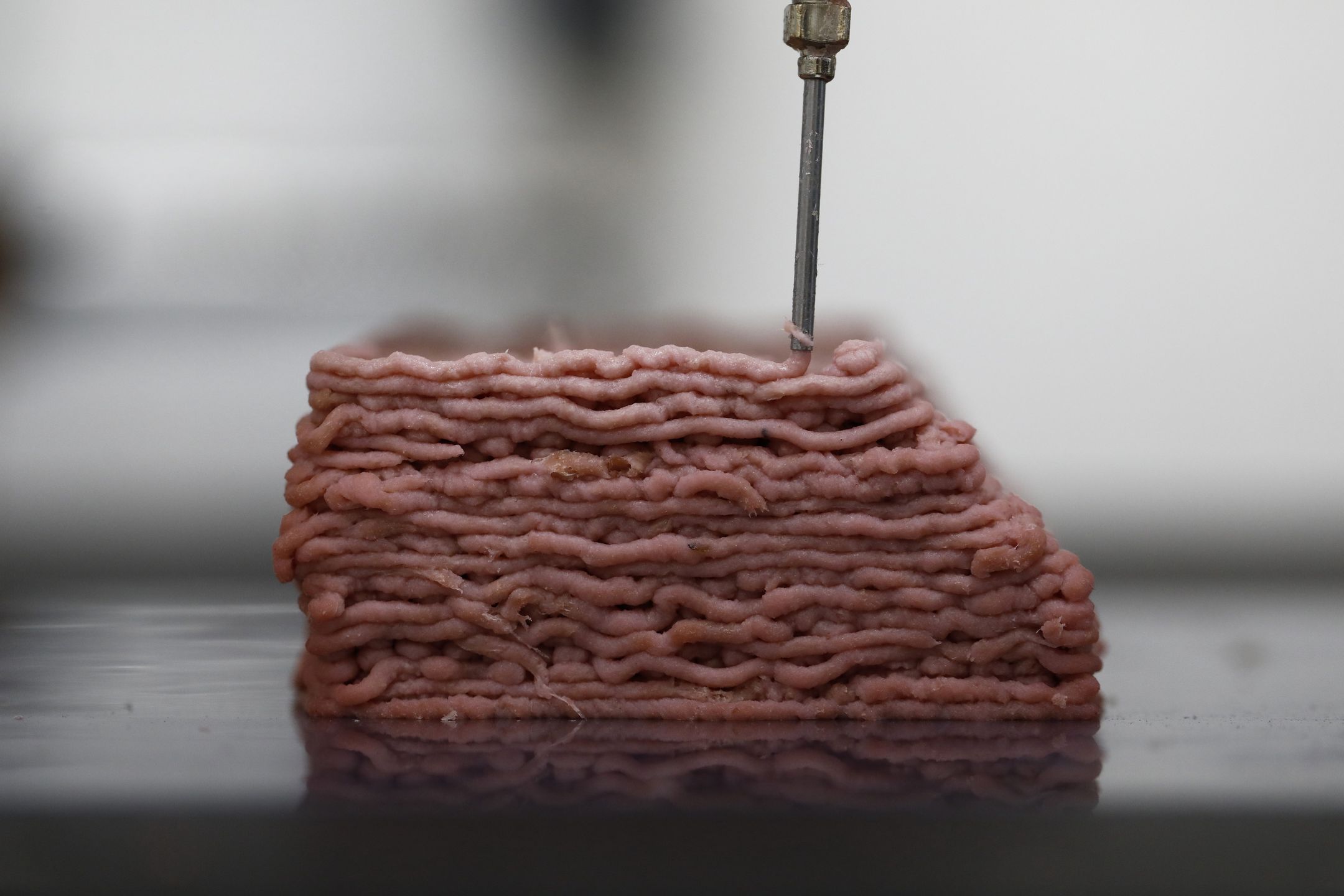 Bloomberg Pictures Of The Year 2019: Tech Unchecked. A 3D printer prints a variation of animal-free meat muscle formulation with colour in the laboratories of Redefine Meat Ltd., in Ness Ziona, Israel, on Monday, Nov. 18, 2019. The march of technology has become a cliche. There were advances designed to make our lives easier, make them more exciting, keep track of us with facial-recognition technology and also replace us. Food is now produced in a way it never used to be with 3D printer technology and Cubic farming. Photographer: Corinna Kern/Bloomberg via Getty Images