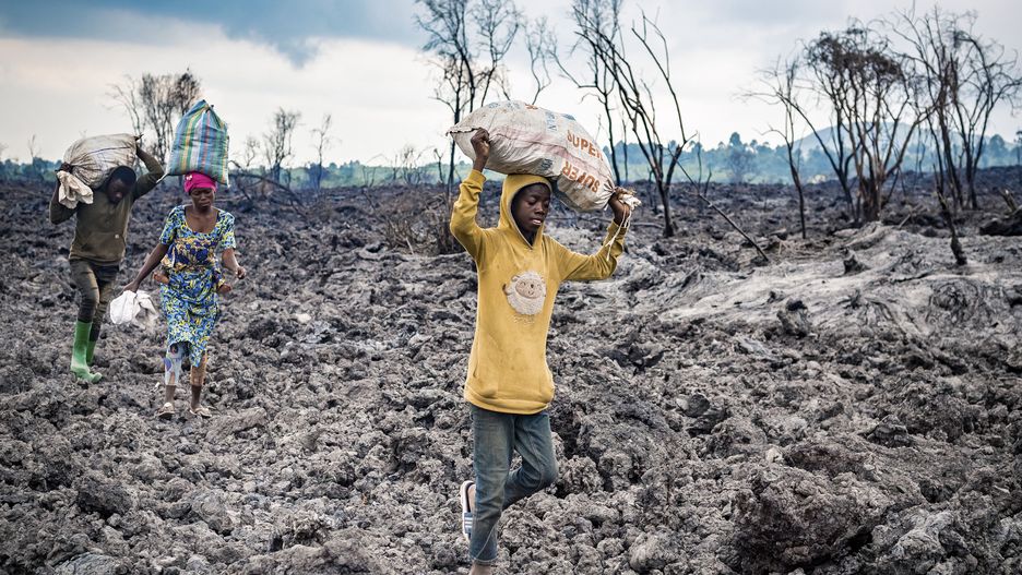 epa09234084 Congolese evacuate across cooled lava from the town of Goma in the aftermath of Mount Nyiragongo volcano over Goma, Democratic Republic of the Congo, 26 May 2021 (issued 28 May 2021). One of the planets most active volcanoes Mount Nyiragongo in eastern Democratic Republic of Congo erupted 22 May 2021. According to the United Nations Childrenâ��s Emergency Fund (UNICEF) it is estimated that the eruption directly affected 20 villages within the area of Kibati, Munigi and Mutaho, representing 3,629 burned houses. This results in around more than 20,000 displaced population. Aftershocks and cracks in the landscape have caused most of Goma to be evacuated during the week. Tens of thousands have fled Goma for surrounding villages.  EPA/Michel Lunanga Dostawca: PAP/EPA.