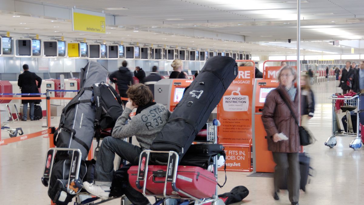 a man sitting on a baggage trolley full of luggage and skis in the easyJet check-in area
a man sitting on a baggage trolley full of luggage and skis in the easyJet check-in area. (Photo by: aviation-images.com/Universal Images Group via Getty Images)
aviation-images.com
airports, insides, interiors, internal, views, terminals, terminal, buildings, bags, suitcases, cases, baggages, checkin, check, in, checking, checking-in, check-ins, check-in, checkins, easy, jet, easy-jet, cost, airlines, carriers, low-cost, low-fare, baggage, gentleman, gentlemen, passengers, customers, seats, chairs, seating, seated, trolleys, trollies, carts