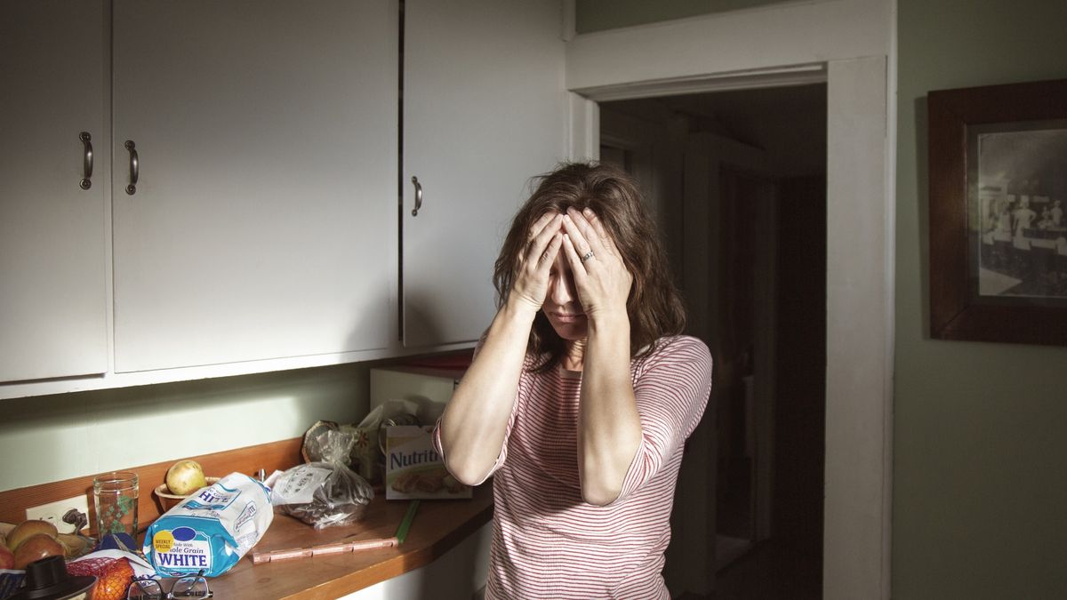 Woman suffering from headache standing in kitchenUSA, Portland, OregonCavan Imagescabinets, female, fruits, mature female, mature woman, stress, suffering, woman