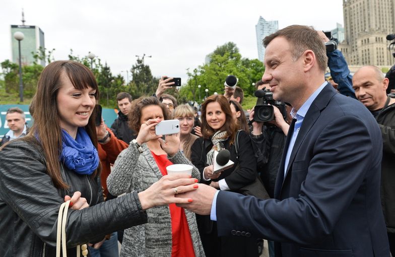 Andrzej Duda rozdaje kawę przed wejściem do metra.