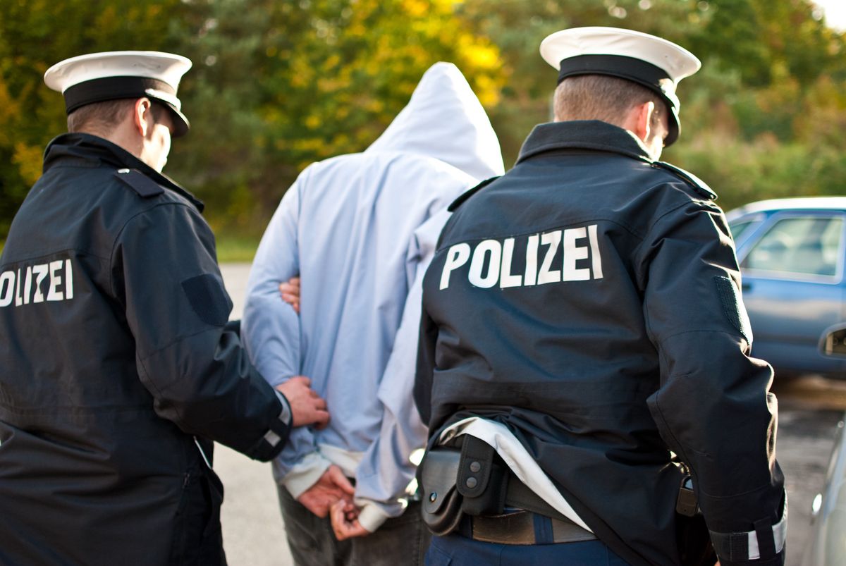 Niemiecka policja z podejrzanym przestępcą. Zdjęcie ilustracyjne