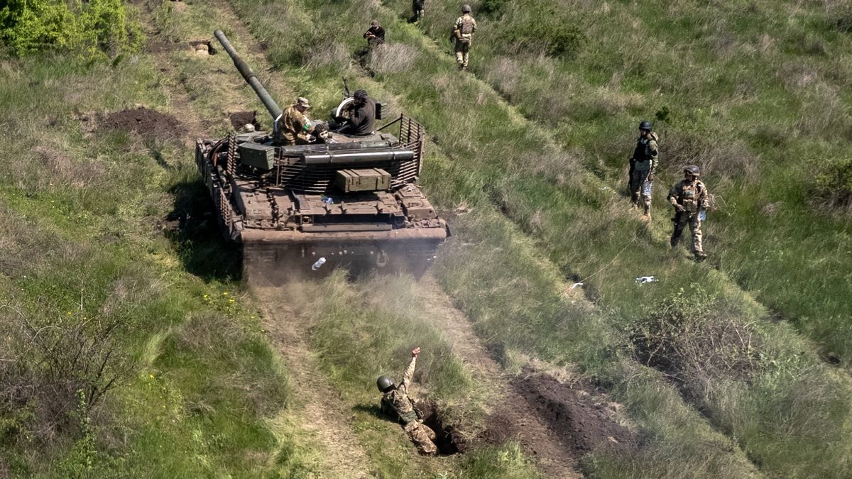 KRYVYI RIH, UKRAINE - MAY 09:  In this aerial view, A Ukrainian infantryman throws a water bottle substitute for a grenade after being driven over by a tank during a training exercise on May 09, 2022 near Kryvyi Rih, Ukraine. Infantry soldiers learned scenarios to survive when potentially confronted with a Russian tank closing in at close range. The frontline with Russian troops lies only 70km to the south in Kherson Oblast, most of which is controlled by Russia. (Photo by John Moore/Getty Images)
