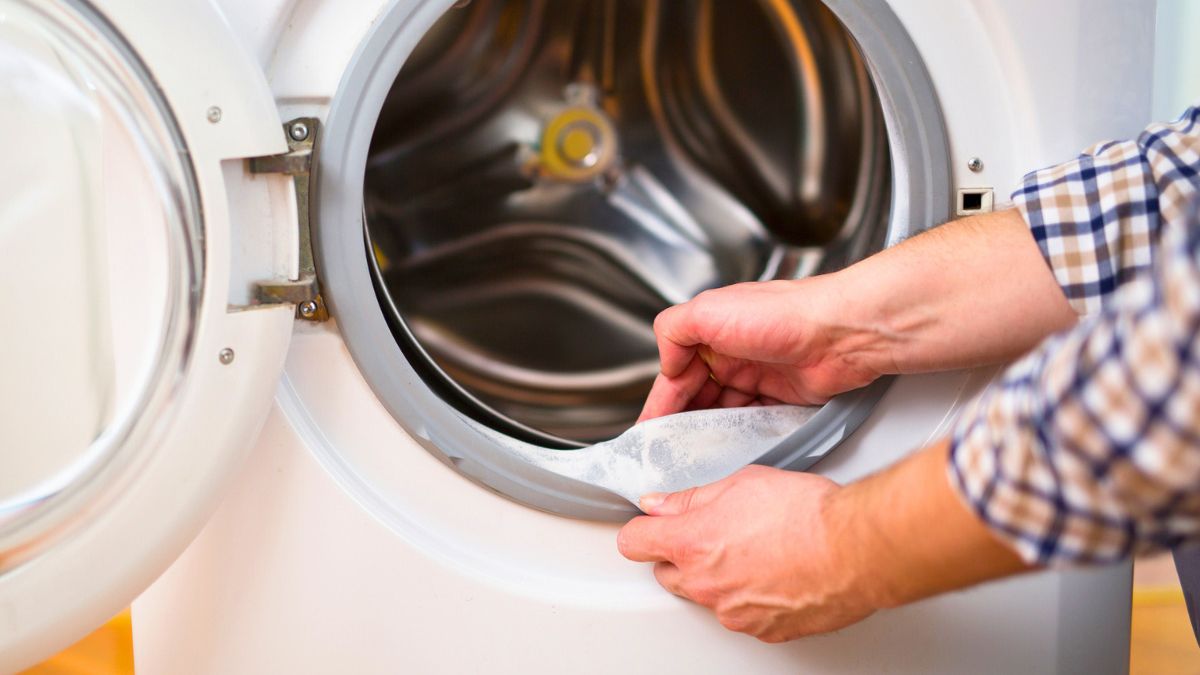 Mężczyzna czyści pralkę