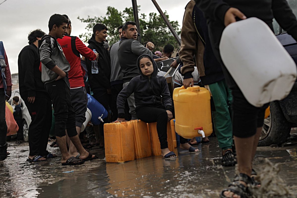 Palestyńczycy czekają na wodę w tymczasowym obozie