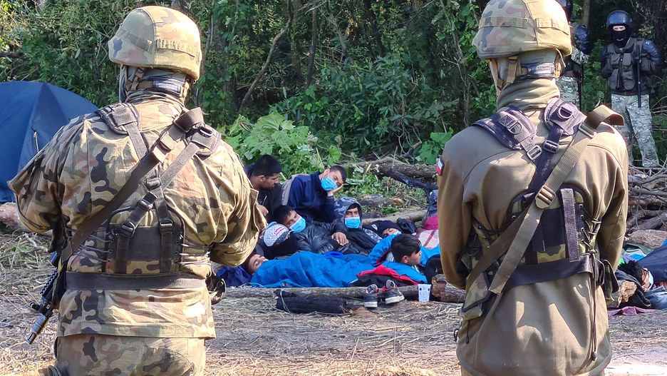 Afghan refugees stranded on Polish-Belarusian borderPODLASIE VOIVODESHIP, POLAND - AUGUST 20, 2021: Armed Polish soldiers and Afghan refugees who have fled the Taliban are seen near the village of Usnarz Gorny in eastern Poland on the border to Belarus. A group of 30 refugees have been stranded at the Polish-Bel) byt