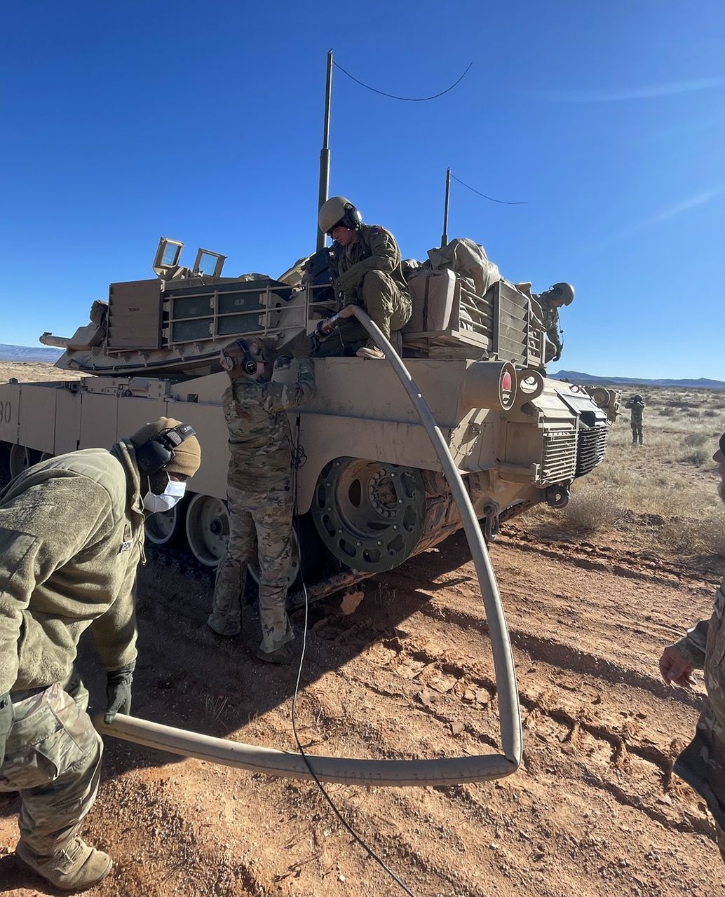 Żołnierze podłączający wąż do wlewu paliwa w czołgu