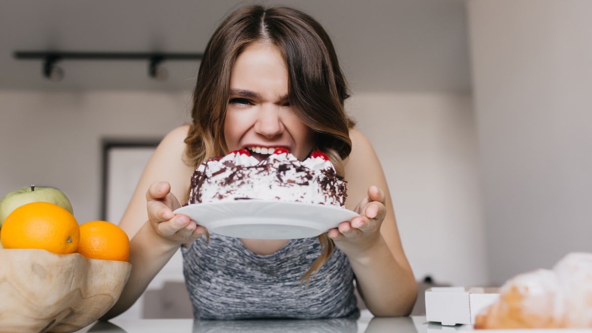 Kobieta jedząca tort czekoladowy z bitą śmietaną
