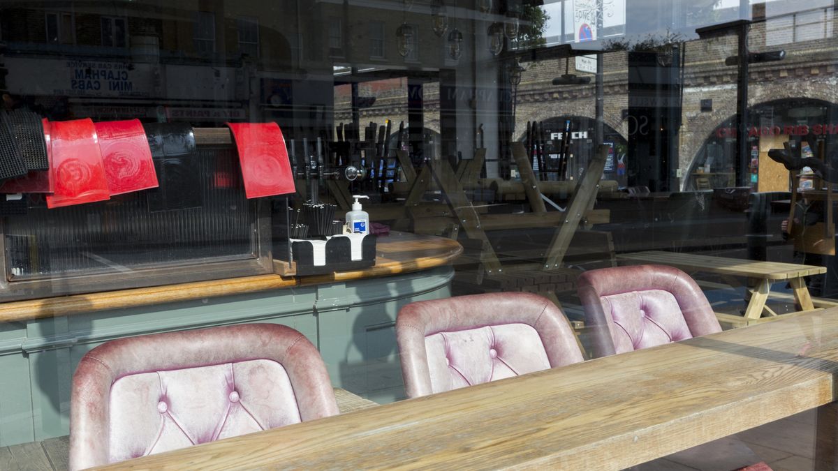 As the second week of the Coronavirus lockdown continues around the capital, and the UK death toll rising by 563 to 2,325, with 800,000 reported cases of Covid-19 worldwide, faded seats and red bar mats are seen in the window of The Railway, a closed pub opposite the railway arches at the local Overground station on Clapham High Street, all in accordance with the government's forced lockdown and closure of businesses, on 1st April 2020, in south London, England. (Photo by Richard Baker / In Pictures via Getty Images)