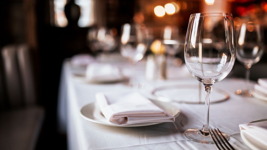A close up shot of a restaurant table set up with tableware and wine glass. Concept of dining, hospitality and catering. Horizontal image with free space for text.
dinner, table, restaurant, setting, romantic, up, set, place, elegant, party, fine, cutlery, wine, menu, catering, white, gold, luxury, evening, glass, silverware, hospitality, glasses, wine glasses, napkins, tableware, eating, dining, service, event, table set up, copy space, space for text, background, restaurant concept, luxurious, private dinner, corporate dinner, corporate event, nobody, reflection, reserved, reservation, booking, elegance, romantic, valentines, indoors, dining area.