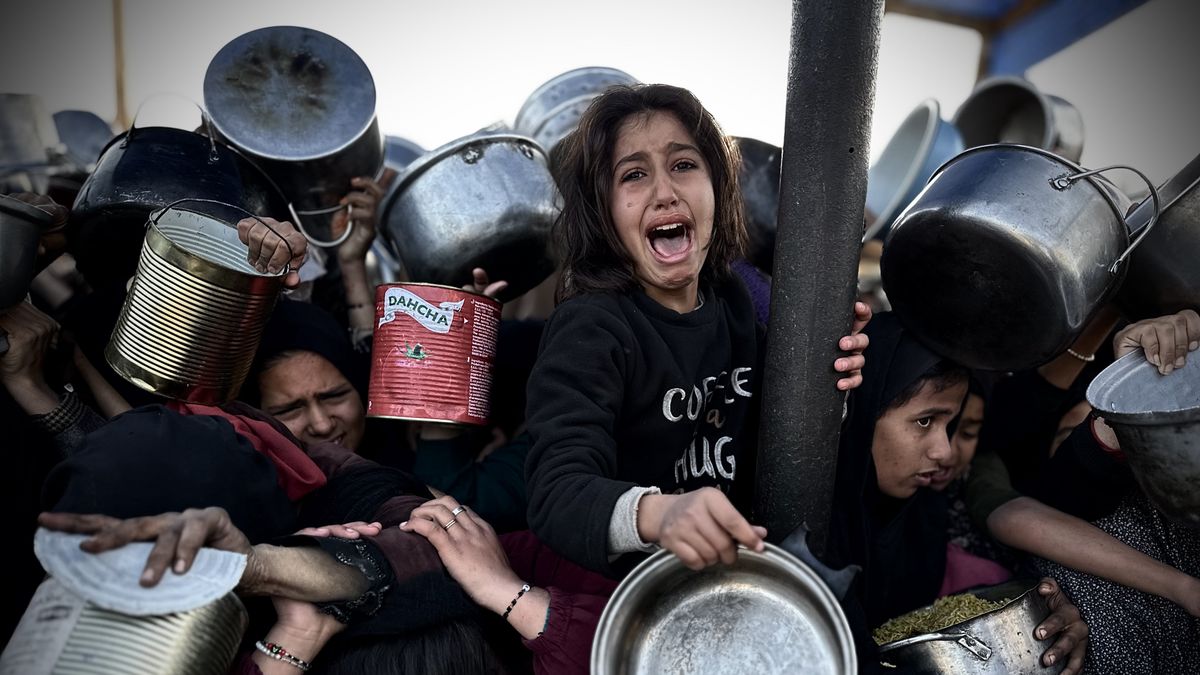 KHAN YUNIS, GAZA - DECEMBER 27: Palestinian children struggle to receive food distributed as Palestinians who escaped from the attacks of the Israeli army and took shelter in the Khan Yunis, located in the south of the Gaza Strip and who are struggling with hunger wait in line to receive meals distributed by charities in Khan Yunis, Gaza on December 27, 2024. While there is a rush during food distribution, citizens are pushing each other to get food. (Photo by Doaa Albaz/Anadolu via Getty Images)