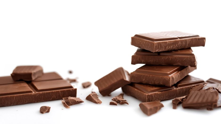 Milk chocolate pieces pattern with side position provides copy space for text. background concept isolated white