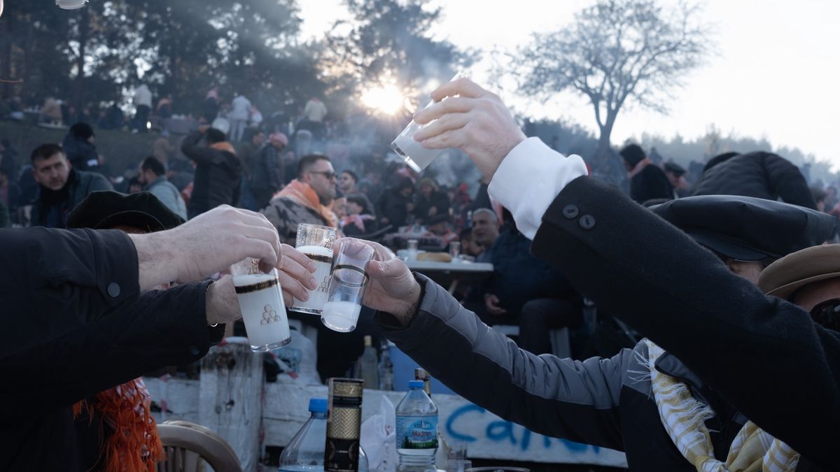 IZMIR, TURKEY - 2025/01/19: Spectators following the camel wrestling clink glasses while drinking raki, a Turkish drink on the sidelines. Camel wrestling, a legacy of nomadic culture in Anatolia is organized between December and March coinciding with the camels' rutting period. The biggest and only international wrestling festival is organized in Selçuk district of Izmir. Efes Selçuk International Camel Wrestling Festival was organized for the 43rd time. Held on January 19 2025, thousands of spectators attended the festival. More than 100 camels participated, while spectators lit barbecues around the arena and drank raki, a Turkish alcoholic drink. (Photo by Murat Kocabas/SOPA Images/LightRocket via Getty Images)