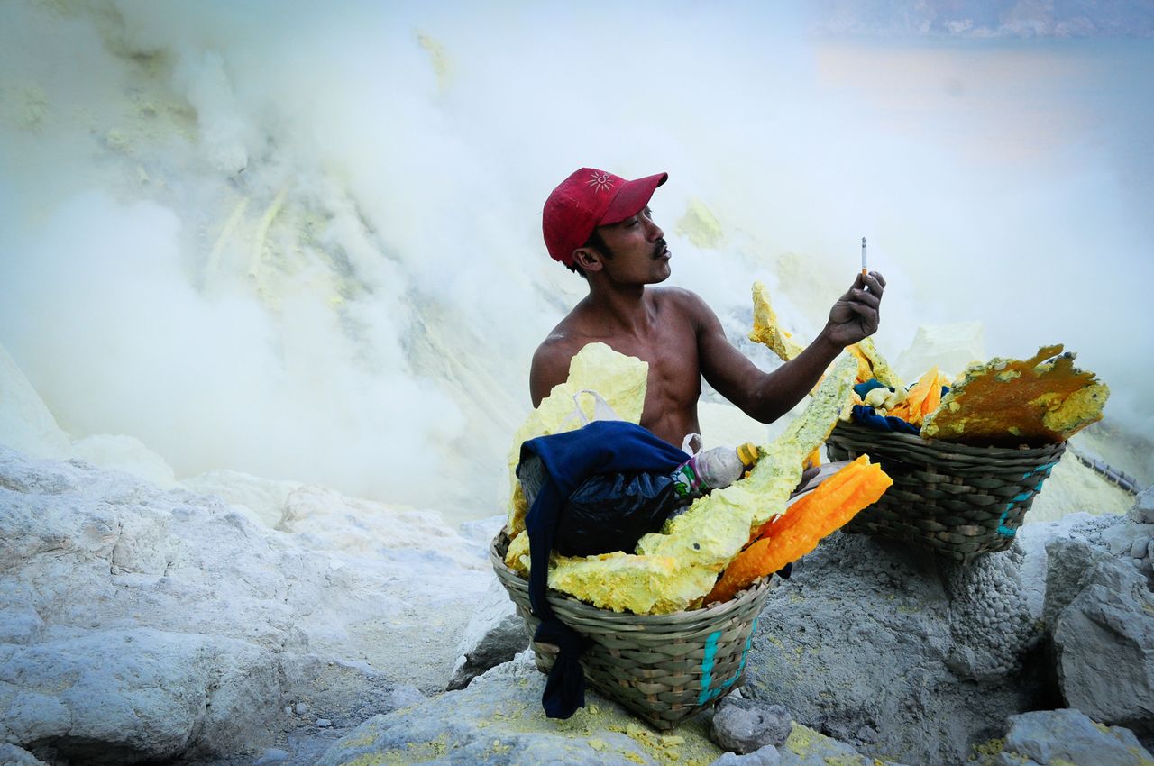 Zdjęcie wykonane na wyspie Jawa. Fotografia ukazuje mężczyznę pracującego przy wydobyciu siarki na dnie krateru wulkanu Kawah Ijen.