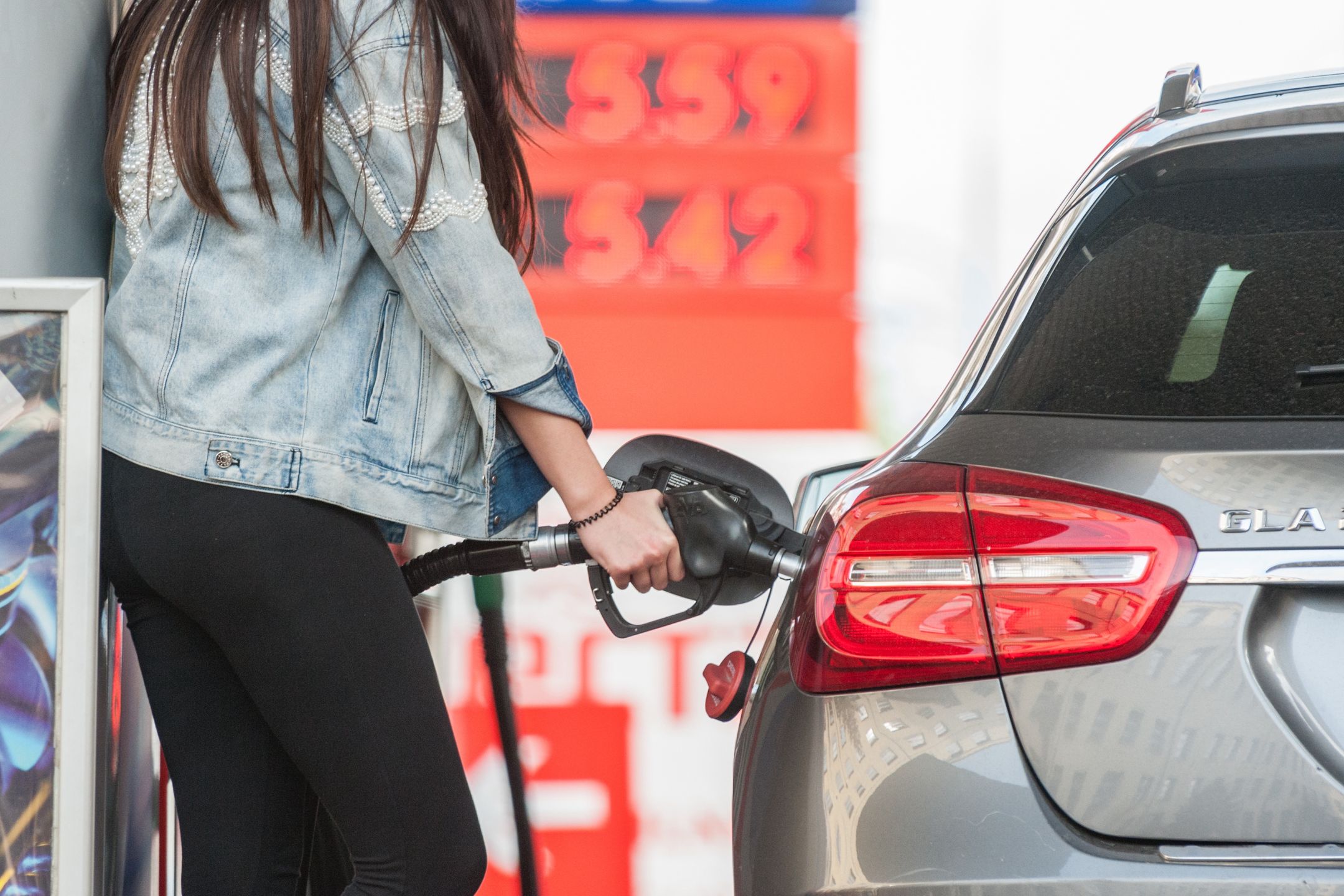tankowanie auta, paliwo, paliwa, benzyna, stacja benzynowa, energia, gaz, przewóz, ropa naftowa, samochód, auto, stacja, transport, zanieczyszczenie powietrza, spaliny, kobieta, cena, ceny, dystrybutor paliwa, pistolet do tankowania, srebrne, czerwone, czerwony
