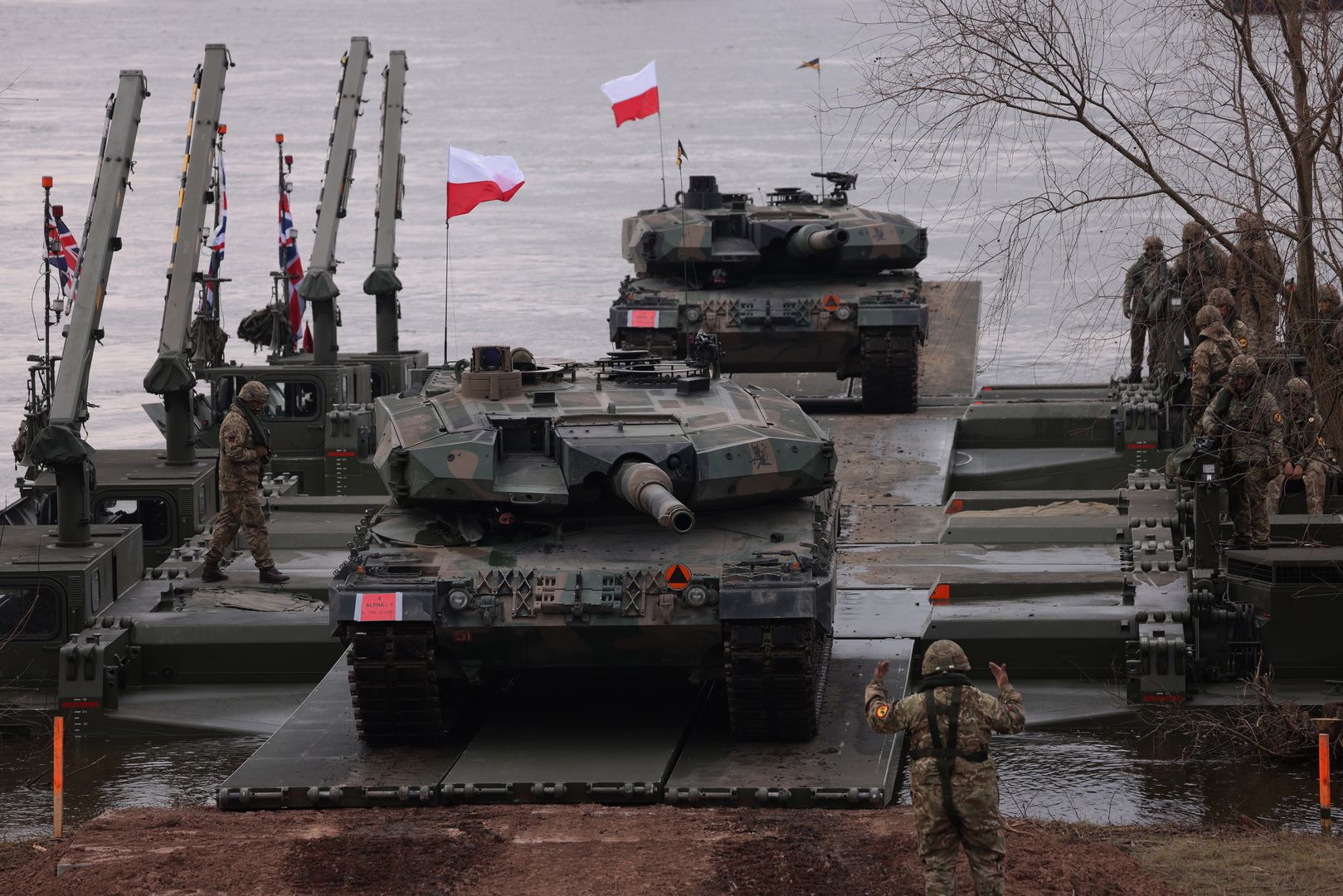 GNIEW, POLAND - MARCH 04: Leopard 2PL main battle tanks of the Polish armed forces descend from M3 amphibious rigs of the German/British Amphibious Engineer Battalion 130 after crossing the Vistula River during the NATO Dragon 24 military exercise on March 04, 2024 near Gniew, Poland. Dragon 24 is involving 20,000 troops from 10 different nations and is part of Steadfast Defender 2024, an ongoing set of NATO military manoeuvres across Europe that is involving 90,000 troops. (Photo by Sean Gallup/Getty Images)