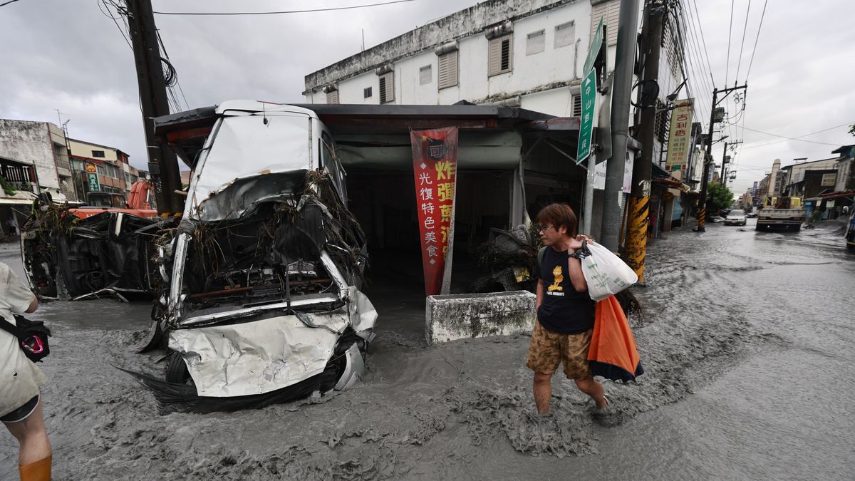 epaselect epa12401219 A man walks past a damaged vehicle on a flooded street in the aftermath of Super Typhoon Ragasa in Guangfu Township, Hualien County, Taiwan, 24 September 2025. At least 14 people have died, 32 were injured and more than 150 are missing in the eastern county after a barrier lake in the mountains overflowed and inundated the township during the typhoon, according to the Ministry of Health and Welfare. EPA/RITCHIE B. TONGO Dostawca: PAP/EPA.