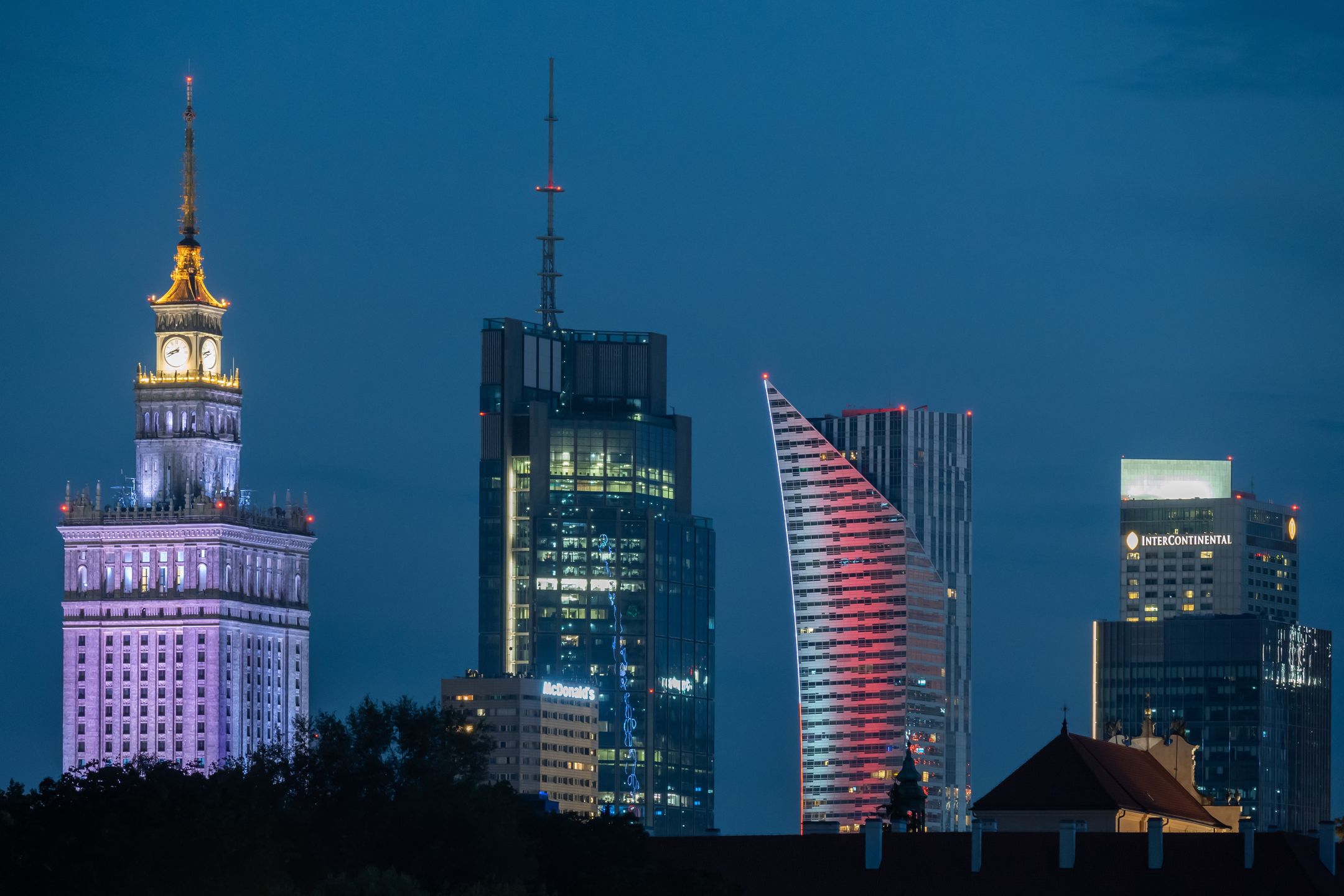 WARSAW, POLAND - 2024/08/17: General overview of the illuminated modern cityscape during night time with skyscrapers of the capital of Poland Warsaw. Seen from left: iconic Palace of Culture and Science (in Polish Palac Kultury i Nauki), highest building of the European Union Varso tower, Warsaw Spire and InterContinental Warsaw. Warsaw is the largest city in Poland and its economic and business centre is a home to 13 skyscrapers buildings, which are at least 150 meters tall. (Photo by Tomas Tkacik/SOPA Images/LightRocket via Getty Images)