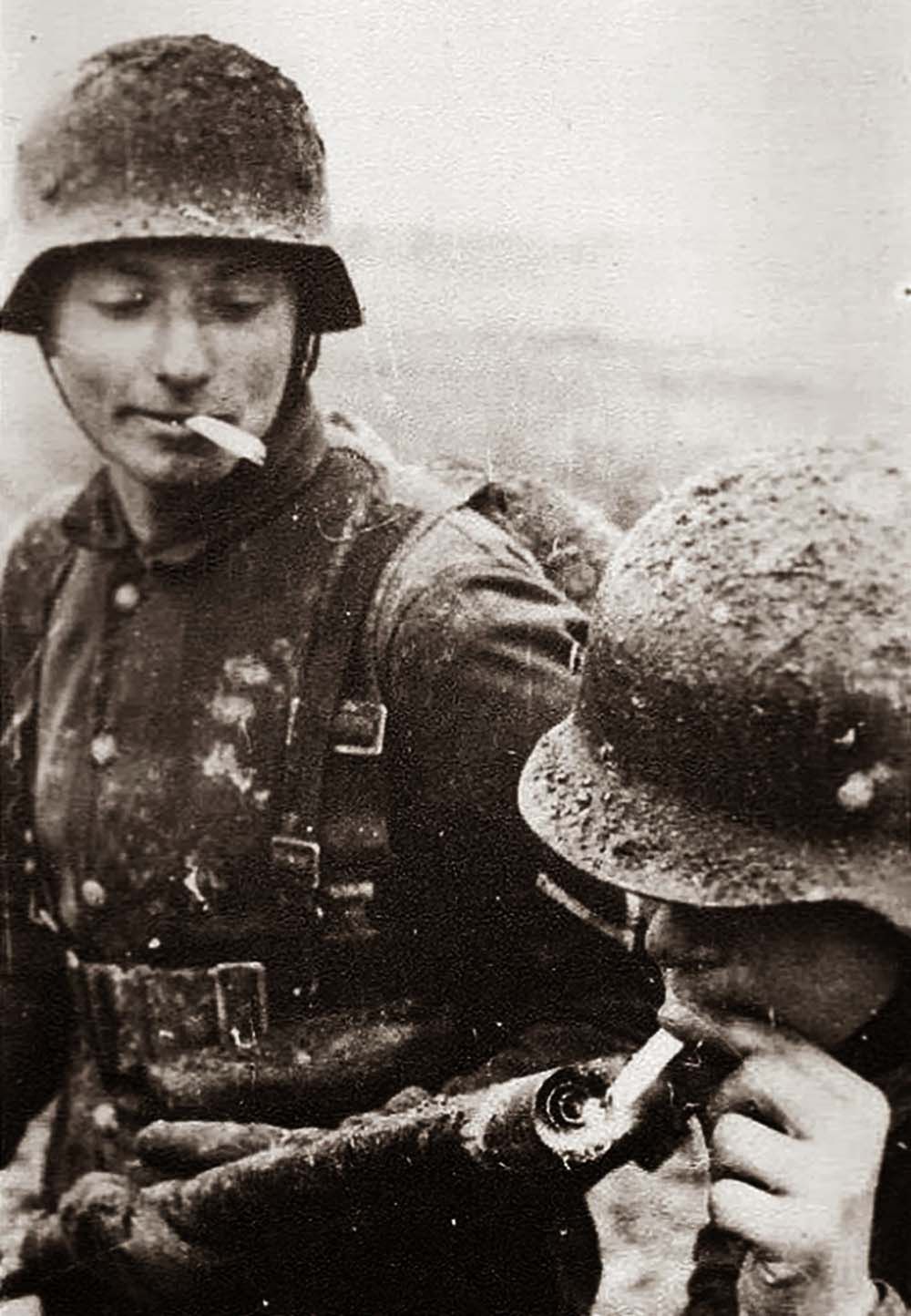Niemiecki żołnierz odpalający papierosa od miotacza ognia