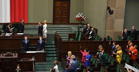 Zaprzysiężenie Andrzeja Dudy. Posłowie Lewicy z egzemplarzami konstytucji, Klaudia Jachira z transparentem "Krzywoprzysięzca"