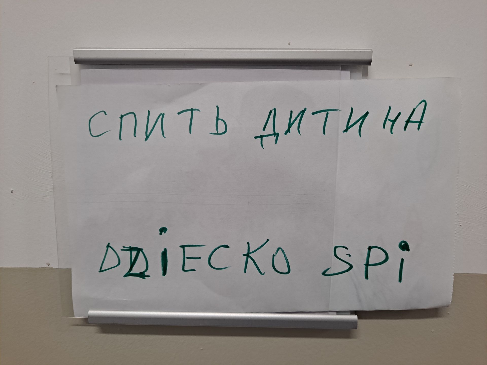 Dwujęzyczna Informacja na drzwiach: dziecko śpi 