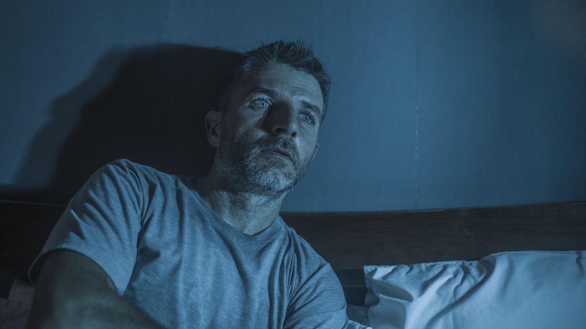 dramatic portrait in the dark of attractive depressed and worried man on bed suffering depression crisis and anxiety feeling lost sitting sleepless in insomnia and life problem conceptdramatic portrait in the dark of attractive depressed and worried man on bed suffering depression crisis and anxiety feeling lost sitting sleepless in insomnia and life problem conceptMarcos Calvo