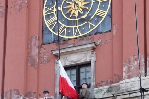 Polską flaga na tle zniszczonej wieży zegarowej. Pawłowicz: "Jakby zawieszono ją na ruinach odbitego z rąk wroga budynku"