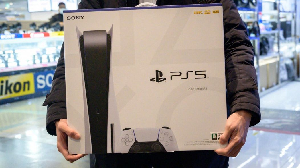Konsola PS5 ju? w sprzeda?yIn a photo taken on November 12, 2020, a customer walks away after purchasing the new Sony Playstation PS5 in Seoul after Sony launched the new console in select markets around the world. (Photo by Ed JONES / AFP)ED JONES