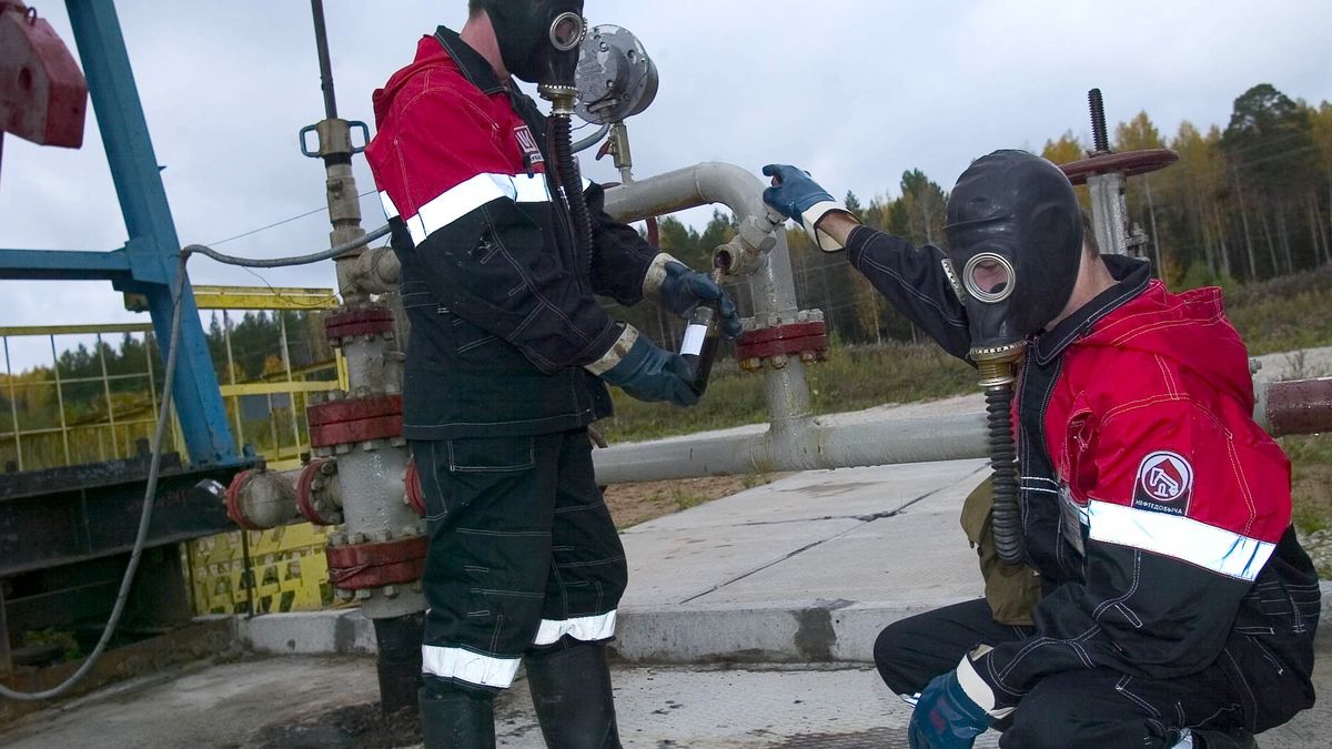 Pracownicy pobierają próbkę ropy do analizy na należącym do Lukoilu polu naftowym Unvinskoje