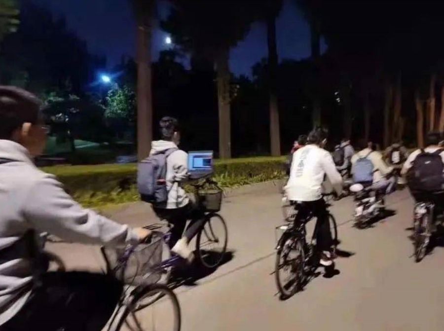 Chiny: Student jedzie na rowerze i jednocześnie pracuje na laptopie