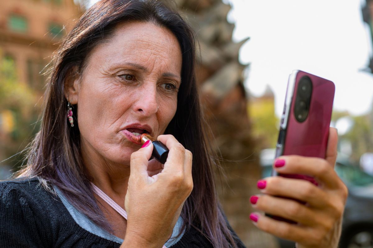 Kobieta maluje usta szminką