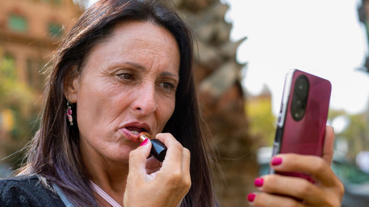 Kobieta maluje usta szminką