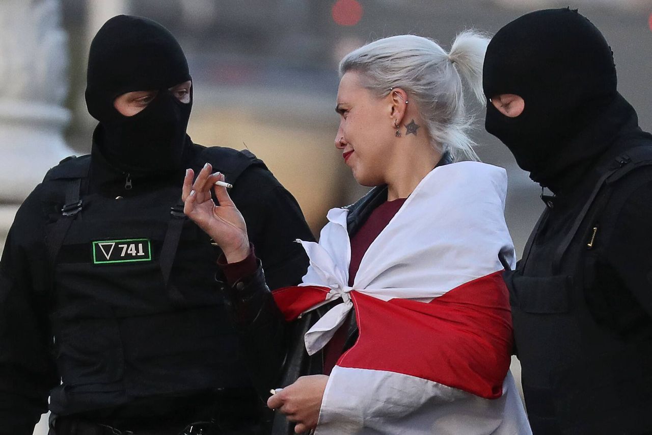 20 września 2020, Mińsk, Białoruś. Kobieta pali papierosa podczas zatrzymania przez funkcjonariuszy organów ścigania podczas wiecu kibiców opozycji w Alei Zwycięstwa.  Fot. Valery Sharifulin/TASS 