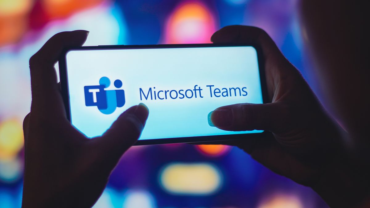 BRAZIL - 2022/07/06: In this photo illustration, a silhouetted woman holds a smartphone with the Microsoft Teams logo displayed on the screen. (Photo Illustration by Rafael Henrique/SOPA Images/LightRocket via Getty Images)