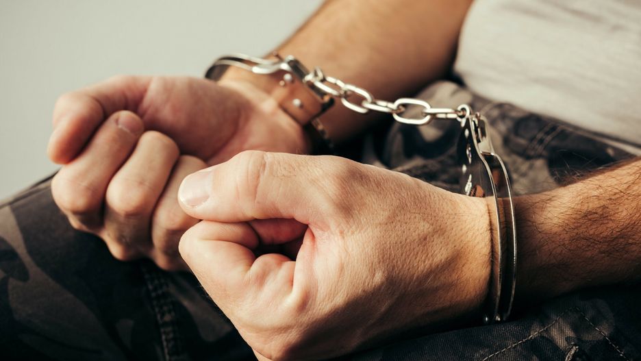 age easyfotostock 2019-02-04Handcuffed soldier in military army clothes. Prisoner of war or arrested terrorist, close up of hands in handcuffs, selective focus.stevanovicigor